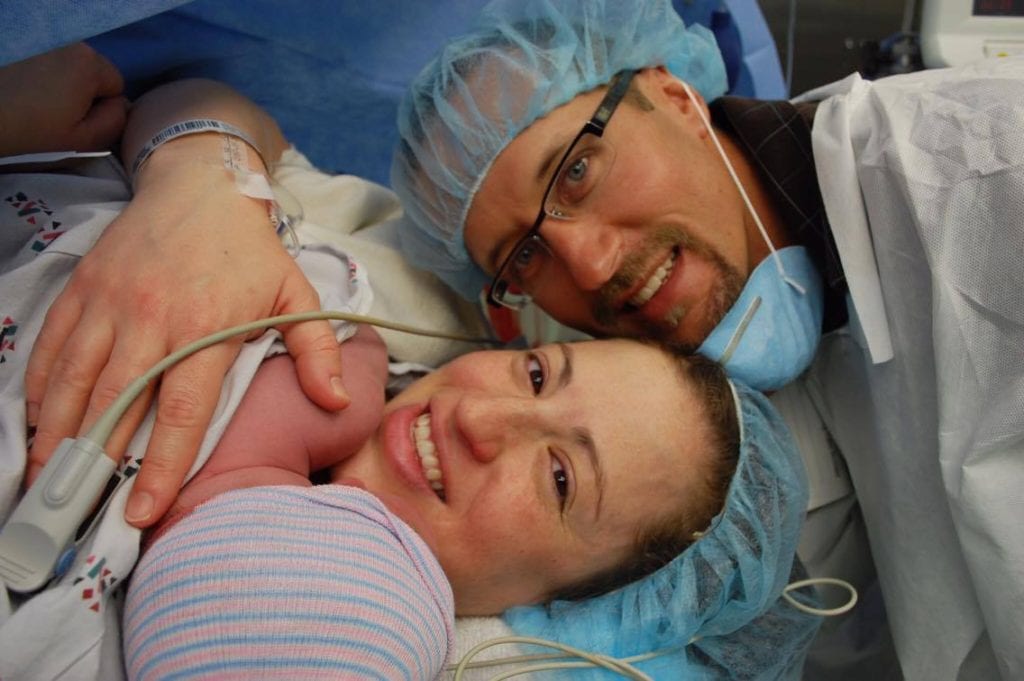mom dad and baby on mom's chest after cesarean delivery in OR
