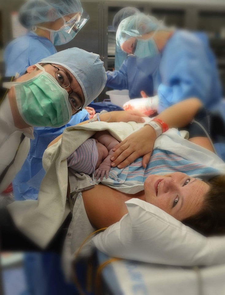 selfie of dad mom and baby in OR after cesarean delivery