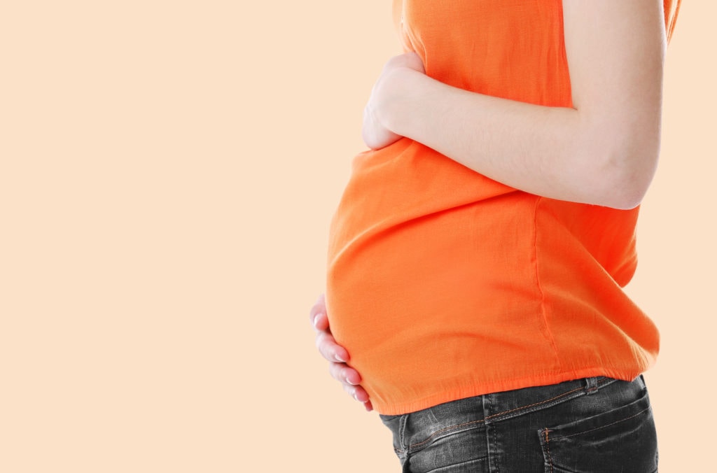 Pregnant woman on light background