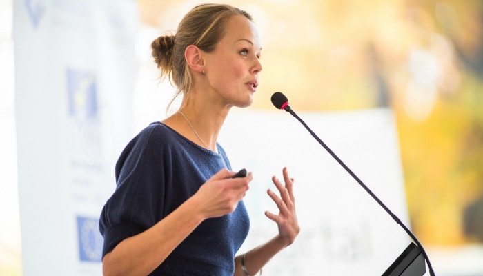 Pretty, young business woman giving a presentation in a conference/meeting setting (shallow DOF; color toned image)