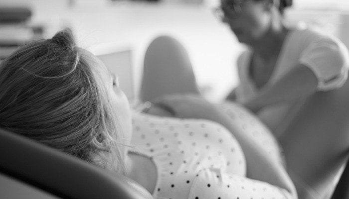 Midwife assists during the third stage of labor.