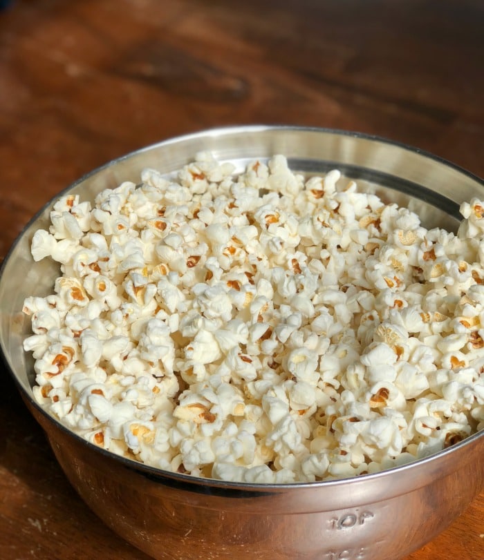 By using my step-by-step instructions you will have perfectly popped coconut oil popcorn made on the stove with minimal (if not zero!) unpopped kernels.  Life goals, people!  Let's get started.