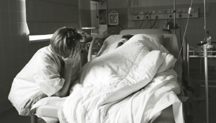 Pregnant woman coping through labor in bed with doula support.