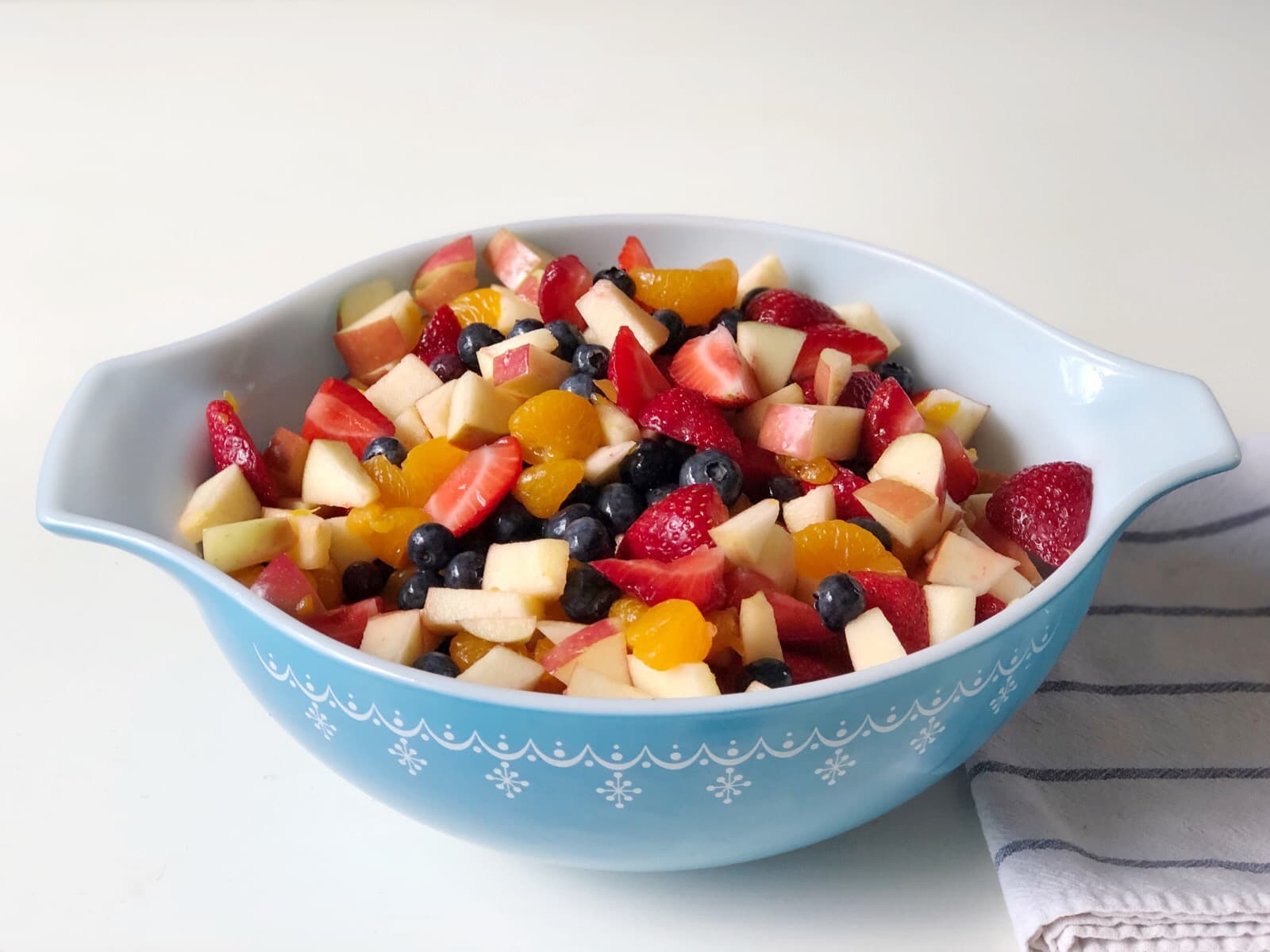 Finished bowl of Chick-Fil-A Fruit Cup copycat recipe in blue bowl on white surface.