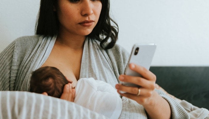 Woman breastfeeding her newborn frequently to avoid holiday mastitis.