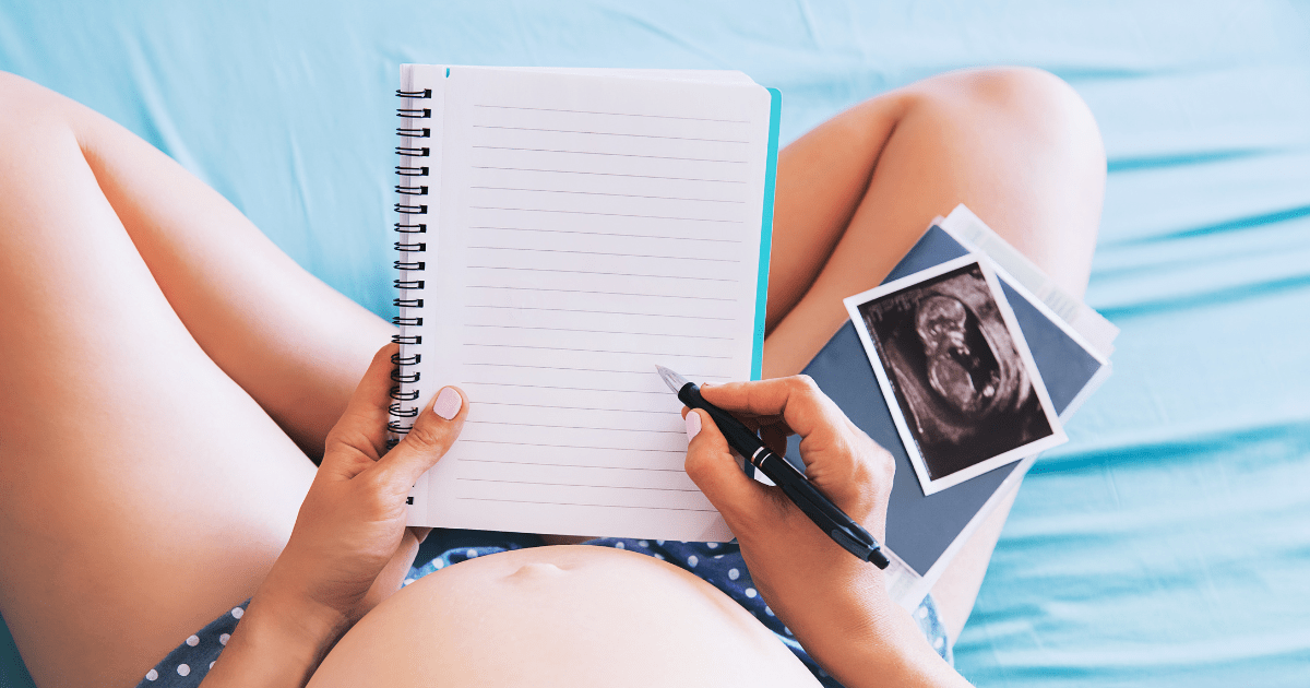 pregnant woman with ultrasound photos and blank notebook ready for pregnancy journal prompts